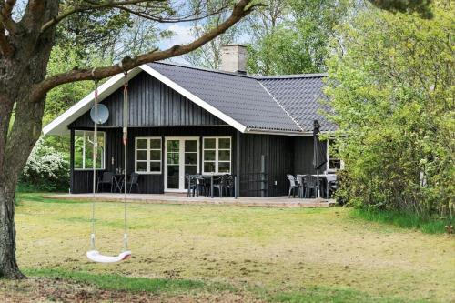 a house with a swing in front of it at 80262-Vemb-Hyttevej-103 in Skalstrup