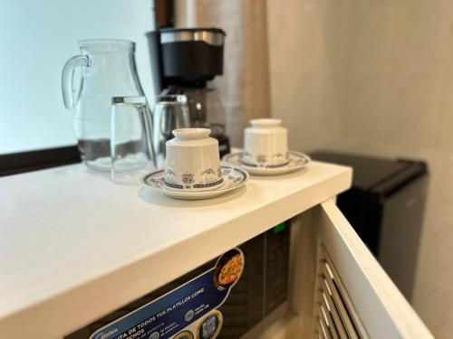 a counter with two plates and a blender on it at Relaxing Suite in Cancun Downtown in Cancún