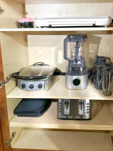 a shelf with a blender and other appliances on it at LE BLEU Charming Poolside Retreat in Bonita Springs