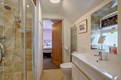une salle de bains avec douche, toilettes et lavabo dans l'établissement Victoria Cottage - Wensum Retreats, à Gunthorpe
