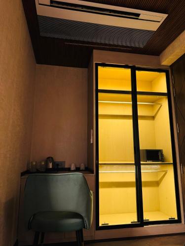 a room with a chair and a glass closet at Dream Stay in Ghaziabad