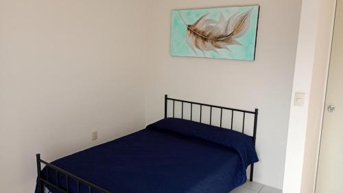 a bedroom with a bed with blue sheets and a picture at Casa Alcatraz con Alberca, Cuernavaca Morelos in Tezoyuca