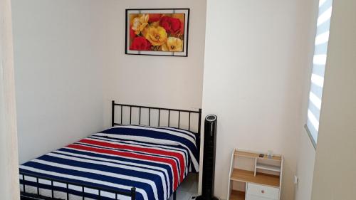 a bedroom with a bed and a painting on the wall at Casa Alcatraz con Alberca, Cuernavaca Morelos in Tezoyuca