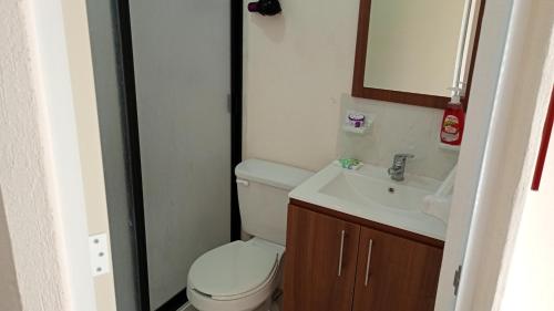 a small bathroom with a toilet and a sink at Casa Alcatraz con Alberca, Cuernavaca Morelos in Tezoyuca