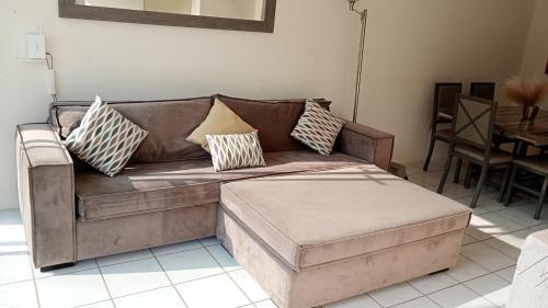 a brown couch with pillows on it in a living room at Casa Alcatraz con Alberca, Cuernavaca Morelos in Tezoyuca