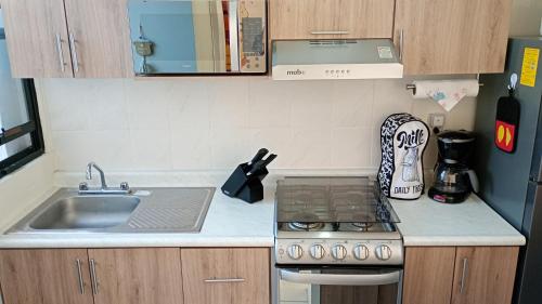a small kitchen with a sink and a stove at Casa Alcatraz con Alberca, Cuernavaca Morelos in Tezoyuca