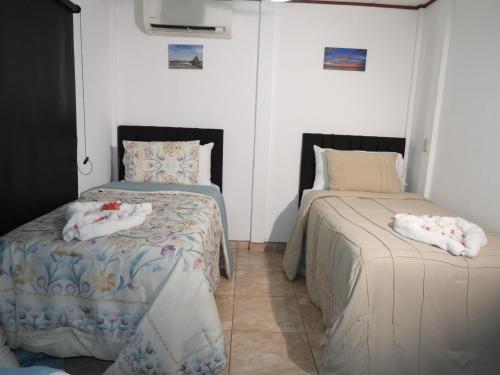 a bedroom with two beds with towels on them at Parti Gras Hotel & Villas en Playa Potrero in Potrero