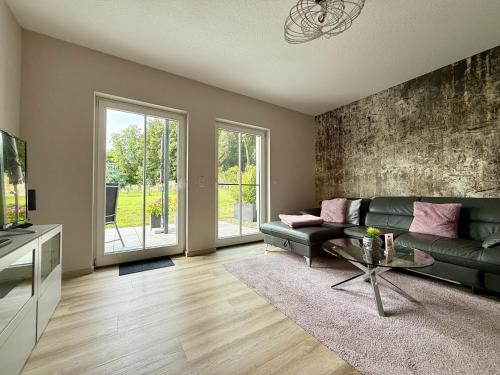 a living room with a green couch and a tv at Ferienwohnung Bertchen - barrierefrei mit Südterrasse und Carport in ruhiger Altstadtlage von Ballenstedt in Ballenstedt