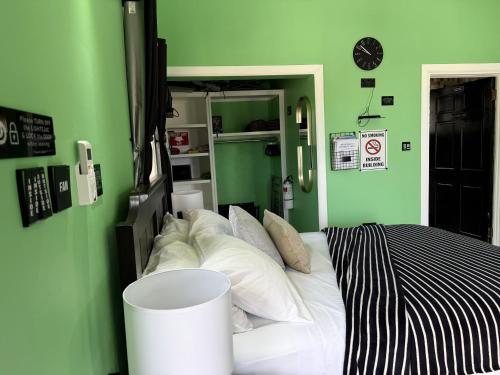 a green bedroom with a bed with white pillows at Maggie's Inn in Soufrière
