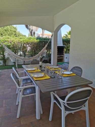a wooden table and chairs on a patio at Luxury 3 bedroom Villa with Private Pool in Cabanas de Tavira