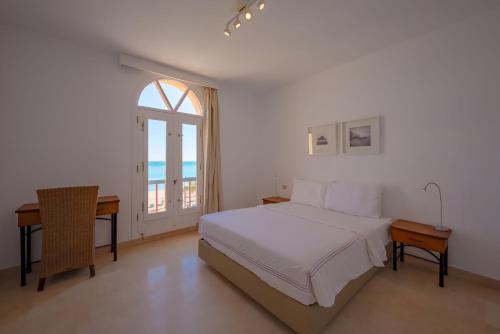 a bedroom with a bed and a desk and a window at Luxury Stays in New Marina, El Gouna in Hurghada