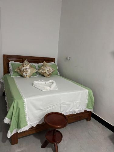 a bedroom with a bed with a chair and a table at Home away from home-Jambiani in Paje