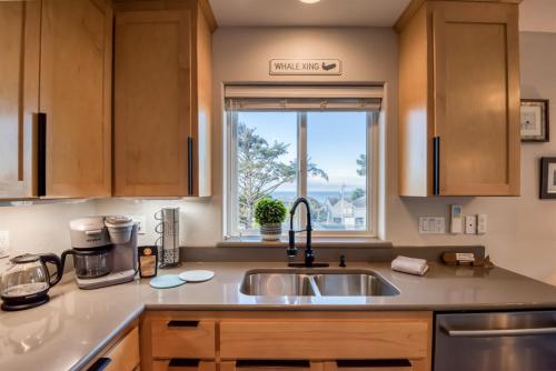 a kitchen with a sink and a window at Pacific Peeks 2 - Oceanview Pet Friendly Retreat with EV Charging fee in Lincoln City