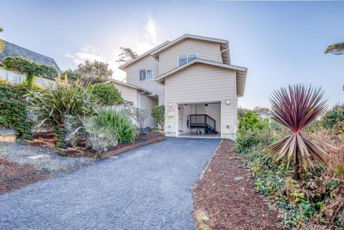 a house with a garage and a driveway at Pacific Peeks 2 - Oceanview Pet Friendly Retreat with EV Charging fee in Lincoln City