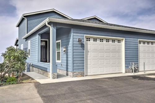 a blue house with a white garage at The Moby House Coastal Retreat with Ocean Views & Hot Tub in Depoe Bay