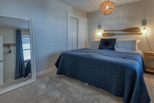 a bedroom with a blue bed and a window at The Moby House Coastal Retreat with Ocean Views & Hot Tub in Depoe Bay