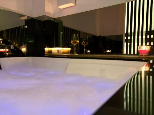 a bath tub with two glasses of wine at Radojkovic Spa Concept in Belgrade