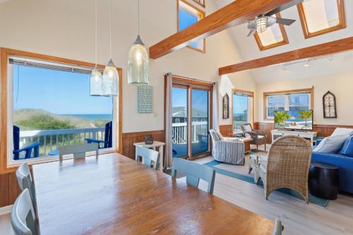 a dining room and living room with a view of the ocean at 5237 - Carpe Dune in Croatan Shores