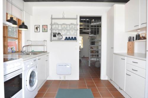 a kitchen with white cabinets and a washer and dryer at 20038-Ulfborg-Knakvej-8 in Vedersø Klit