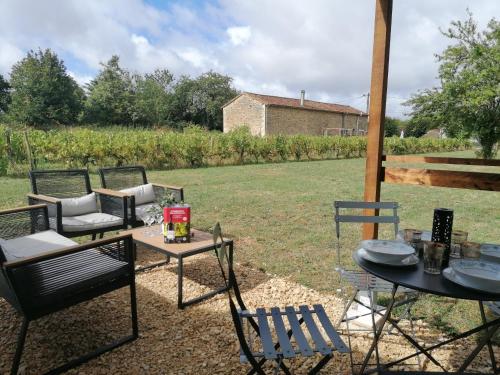 a group of chairs and tables in a yard at Cabane Feuille - Glamping on a vineyard - Wooden Cabin in Savigné