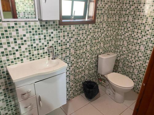a bathroom with a toilet and a sink at Hospedagens Maromba in Itatiaia