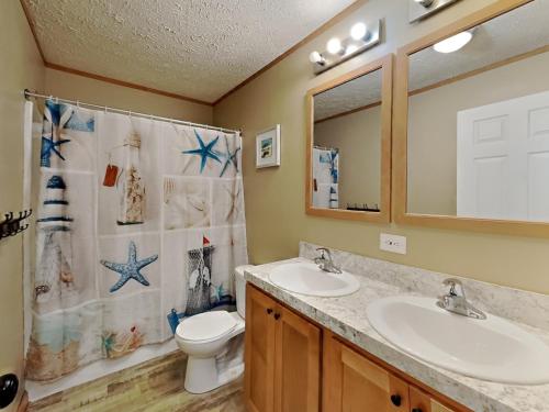 a bathroom with two sinks and a toilet and a mirror at Island Club #111 in Put-in-Bay