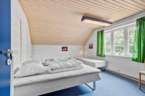 two beds in a room with green curtains at C11605-Olgod-Herningvej-10 in Ølgod