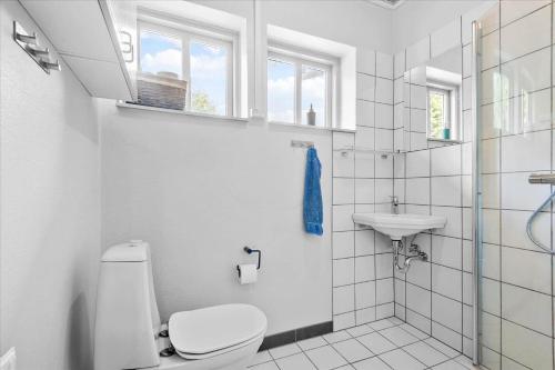 a white bathroom with a toilet and a sink at C11605-Olgod-Herningvej-10 in Ølgod