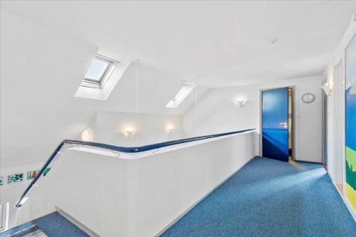 a staircase in a room with a blue carpet at C11605-Olgod-Herningvej-10 in Ølgod