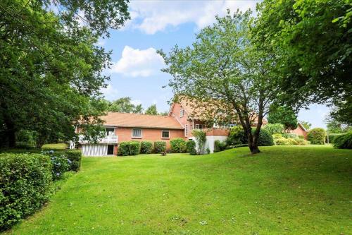 a house with a green yard with a tree at C11605-Olgod-Herningvej-10 in Ølgod