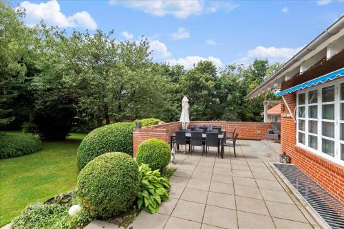 a garden with a table and chairs on a patio at C11605-Olgod-Herningvej-10 in Ølgod