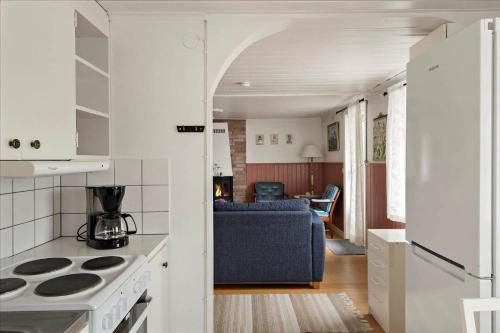 a kitchen and living room with a stove and a couch at KRO175-Vaexjoe-Hissoevaegen-7 in Hov