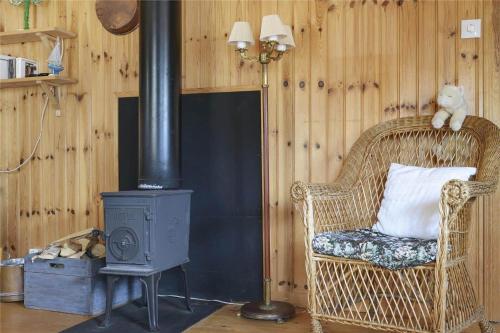 a room with a wicker chair and a wood stove at BOH131-Henan-Tryckhalan-171 in Slussen