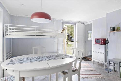 a white dining room with a table and a bunk bed at BOH131-Henan-Tryckhalan-171 in Slussen