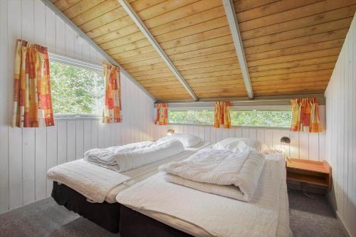 two beds in a room with wooden ceilings and windows at JB329-Brovst-Egernvej-29 in Bratbjerg