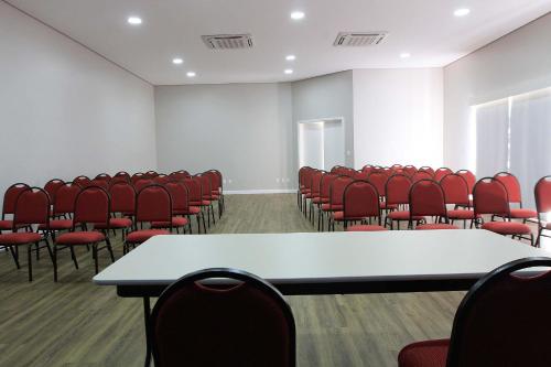 an empty conference room with red chairs and tables at The World Indaiatuba in Indaiatuba