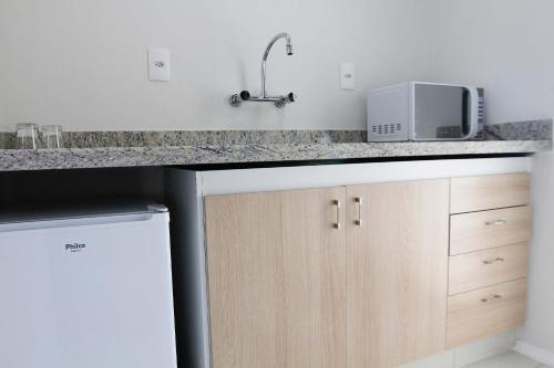 a kitchen counter with a sink and a microwave at The World Indaiatuba in Indaiatuba