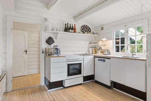a white kitchen with a stove and a sink at 1582-Dronningmolle-Hulerodvej-33 in Dronningmølle