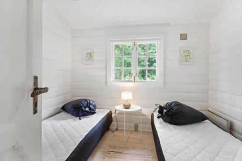 a room with two beds and a window at 1582-Dronningmolle-Hulerodvej-33 in Dronningmølle