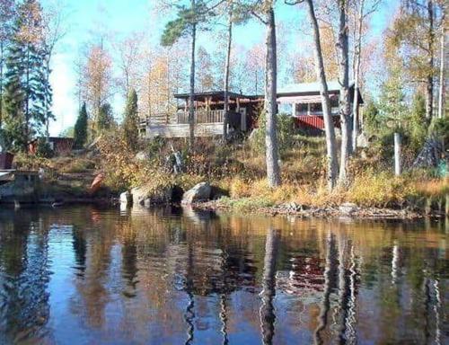 a house sitting on the side of a river at ORE735-Tived-Bosjoen-4 in Tivedstorp