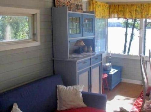 a living room with a blue couch and a kitchen at ORE735-Tived-Bosjoen-4 in Tivedstorp