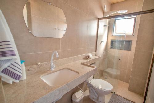a bathroom with a sink and a toilet and a mirror at Ap superior Amanita Kite Home - vista mar piscina in Ponta do Anel