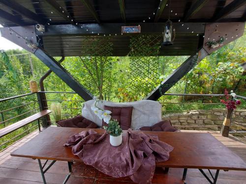 a wooden table and a couch on a deck at Casuta cu Trandafiri in Slănic