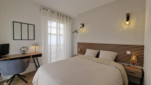 a bedroom with a bed and a desk and a computer at Appartement moderne & cosy - cœur de Libourne Bastide in Libourne