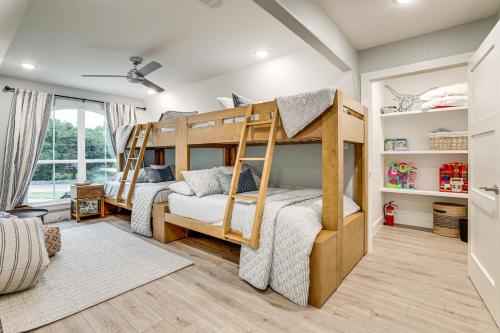 a bedroom with two bunk beds and a living room at Dock and Hot Tub! High-End Cedar Creek Lake Retreat in Gun Barrel City