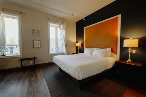 a bedroom with a large bed and two windows at Mercer Hotel Downtown; BW Premier Collection in Stratford