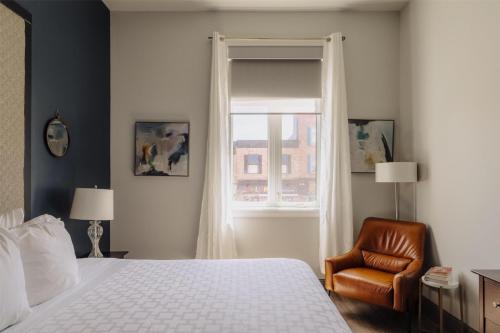 a bedroom with a bed and a chair and a window at Mercer Hotel Downtown; BW Premier Collection in Stratford