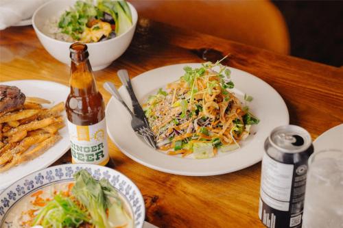 a table with plates of food and a bottle of beer at Mercer Hotel Downtown; BW Premier Collection in Stratford