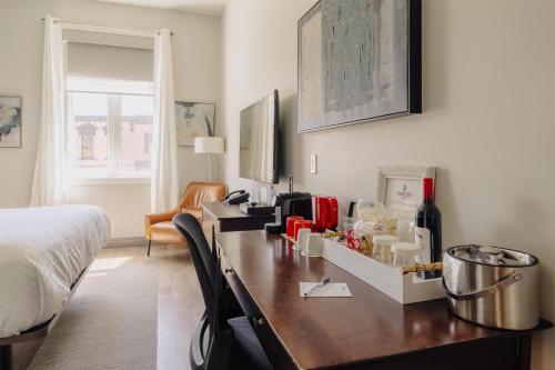 a bedroom with a desk with a bottle of wine at Mercer Hotel Downtown; BW Premier Collection in Stratford