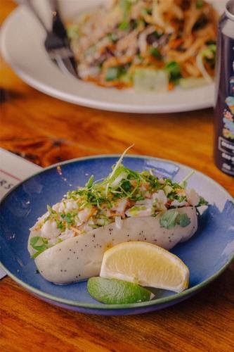 a blue plate with a fish dish with a slice of lemon at Mercer Hotel Downtown; BW Premier Collection in Stratford